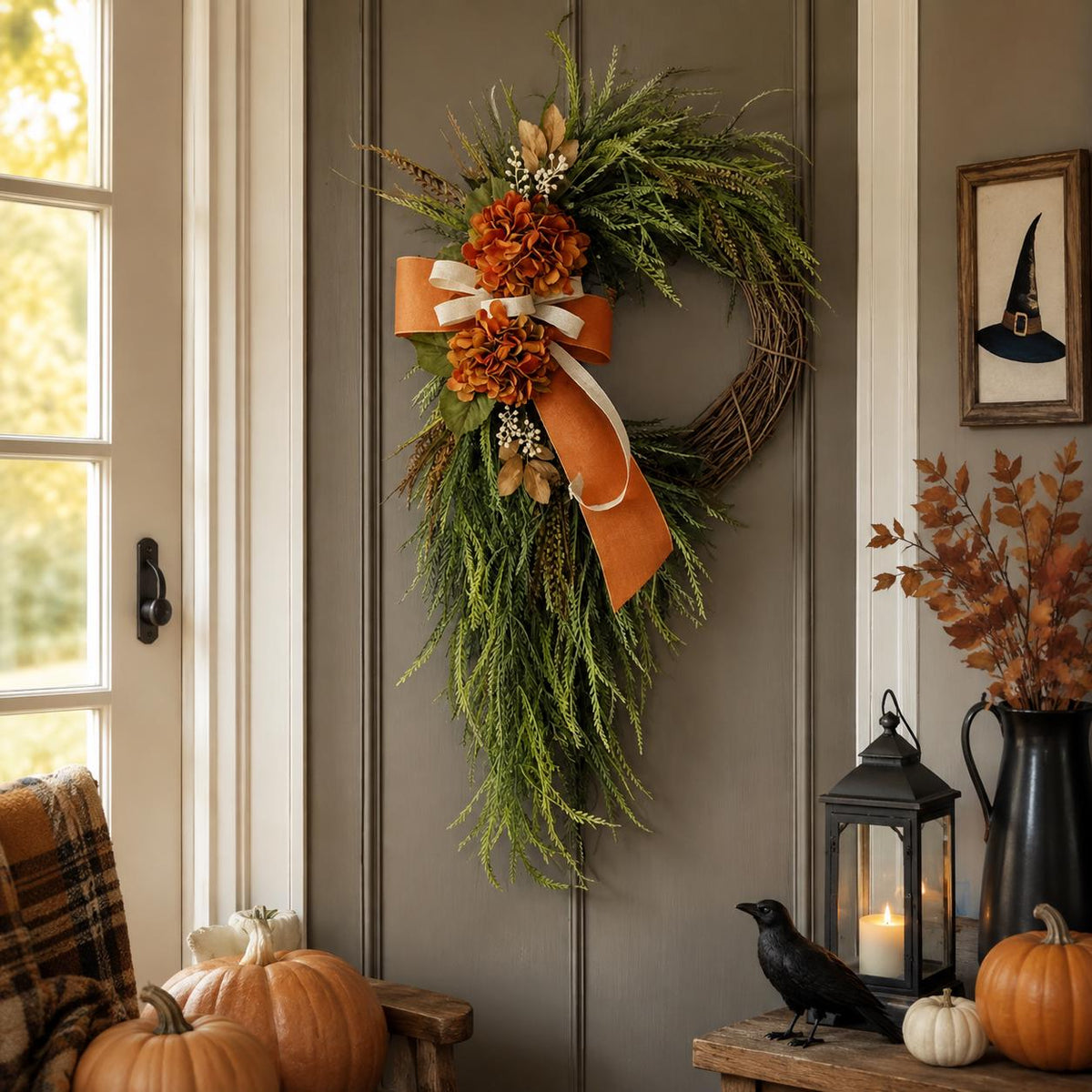 Fall hydrangea wreath with burnt orange blooms and cascading green fronds on a pale panelled front door